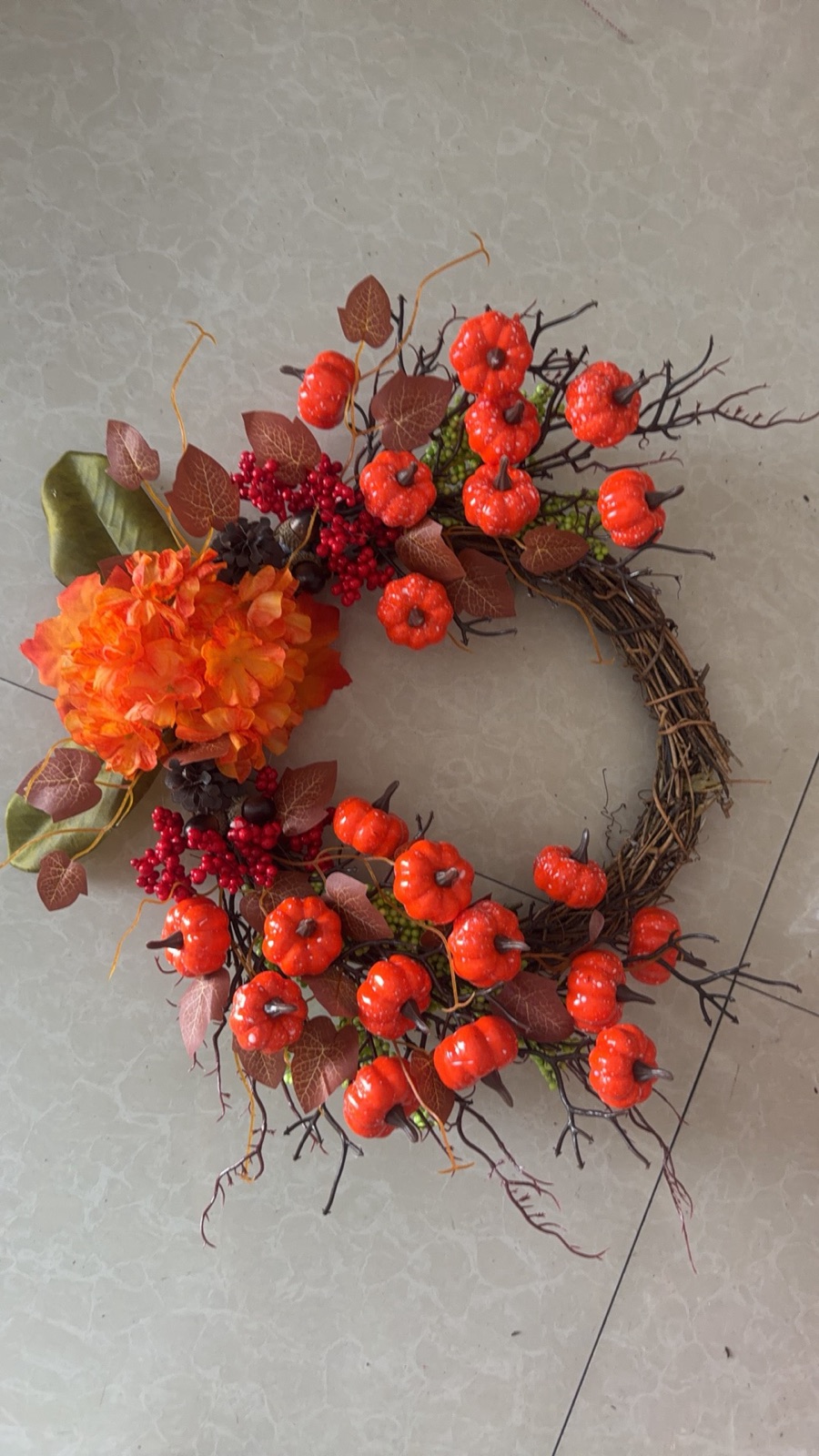 Autumn pumpkin wreath with orange flowers
